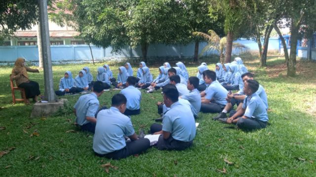 Laila, seorang guru yang mengajar di SMAN Lahat sedang bersama para siswa melaksanakan kegiatan belajar diluar ruangan
