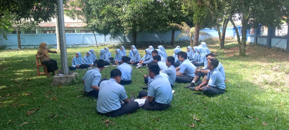 Laila, seorang guru yang mengajar di SMAN Lahat sedang bersama para siswa melaksanakan kegiatan belajar diluar ruangan